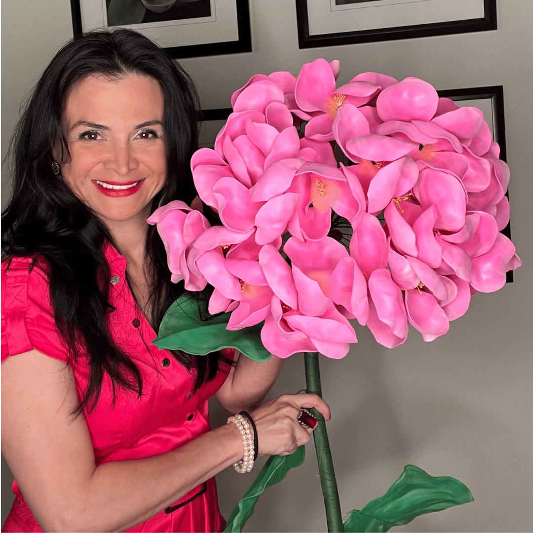 Woman holding completed giant blue-purple hydrangea foam flower from DIY craft kit by Amazing Giant Flowers