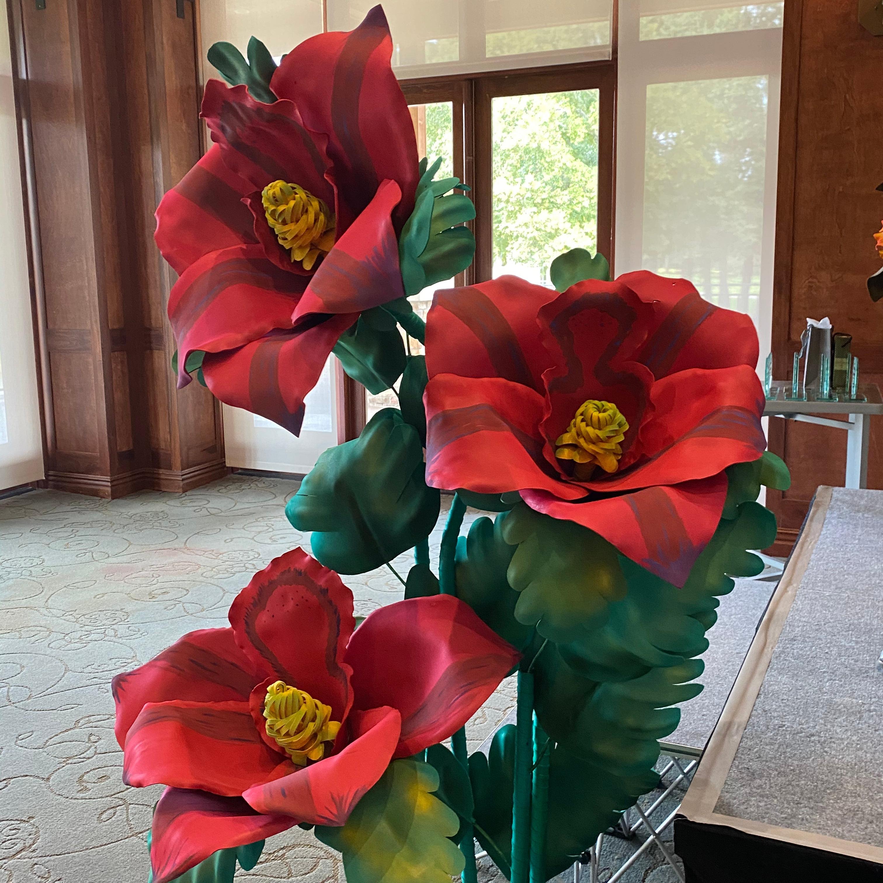 Giant hibiscus and lily foam flower arrangement in tropical pink and green colors for event staging
