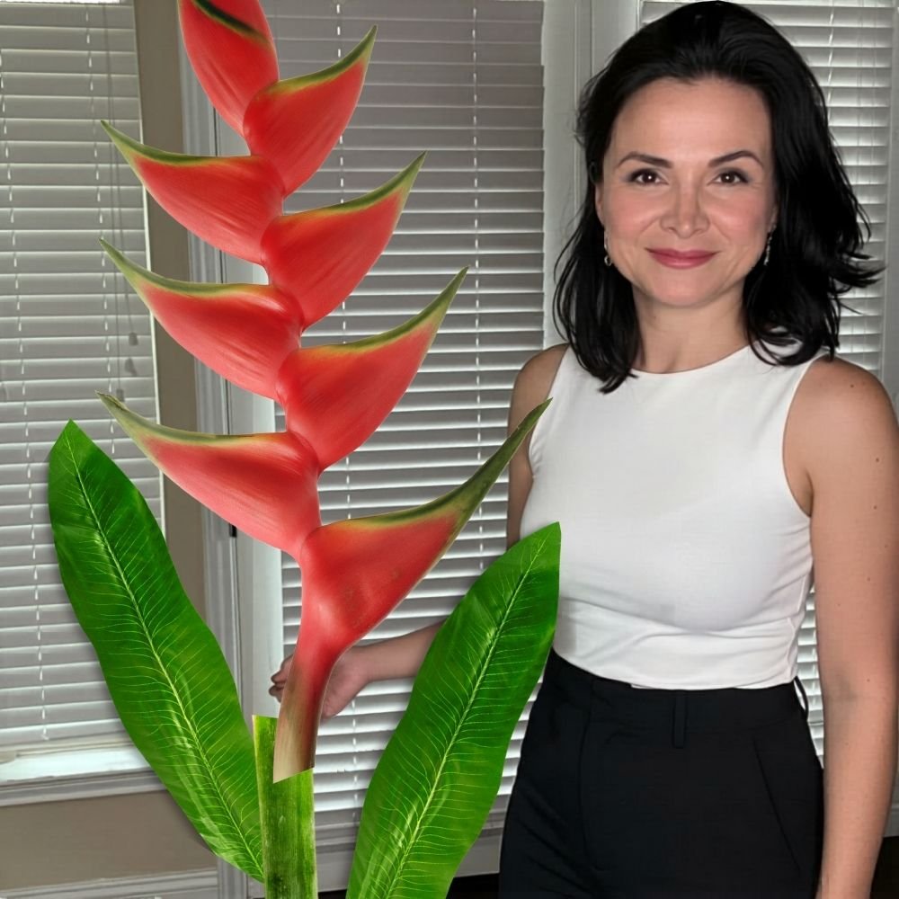 Woman holding completed giant red and green heliconia tropical flower from DIY foam flower kit