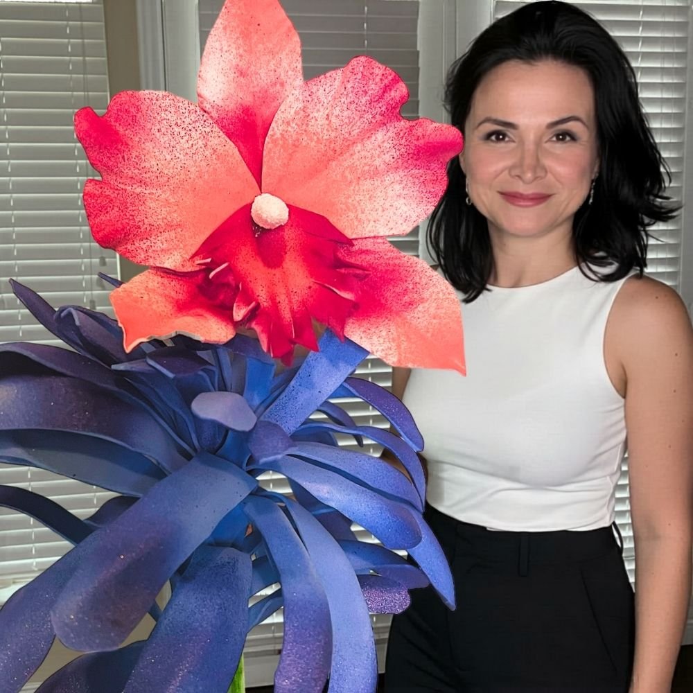 Woman holding giant pink sea orchid waterproof foam flower for pool party and outdoor tropical decor