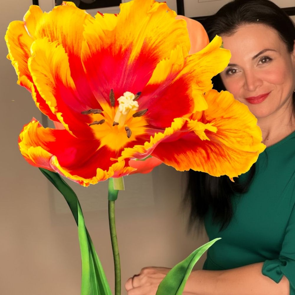 Woman holding giant parrot tulip foam flower in orange-green tropical colors from easy 3-step DIY kit