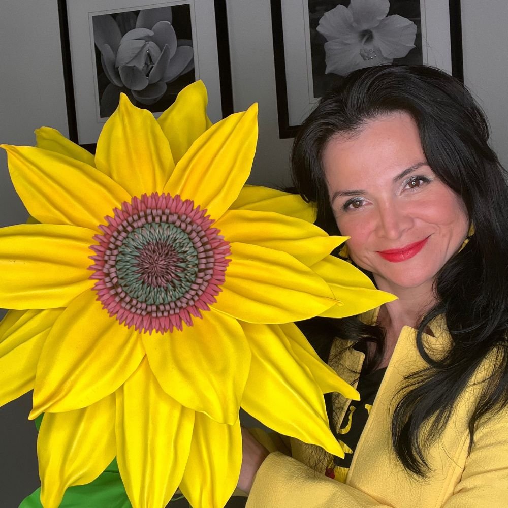Giant yellow sunflower wall statement flower with woman showing scale of oversized DIY foam sunflower kit